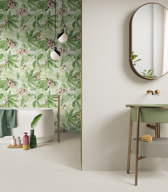 Modern bathroom featuring a tropical-patterned wall, white freestanding bathtub, and green sink with an oval mirror.